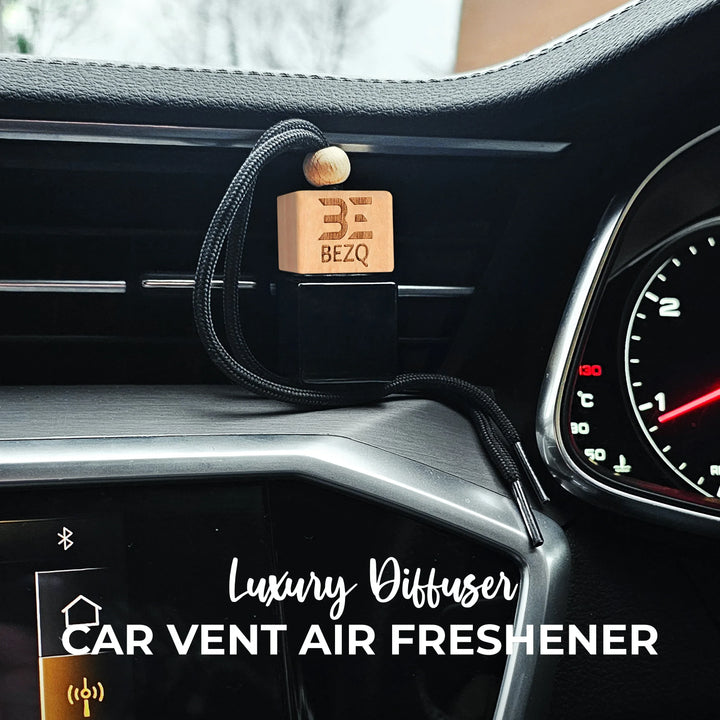 Wooden car vent air freshener diffuser hanging on modern car dashboard.